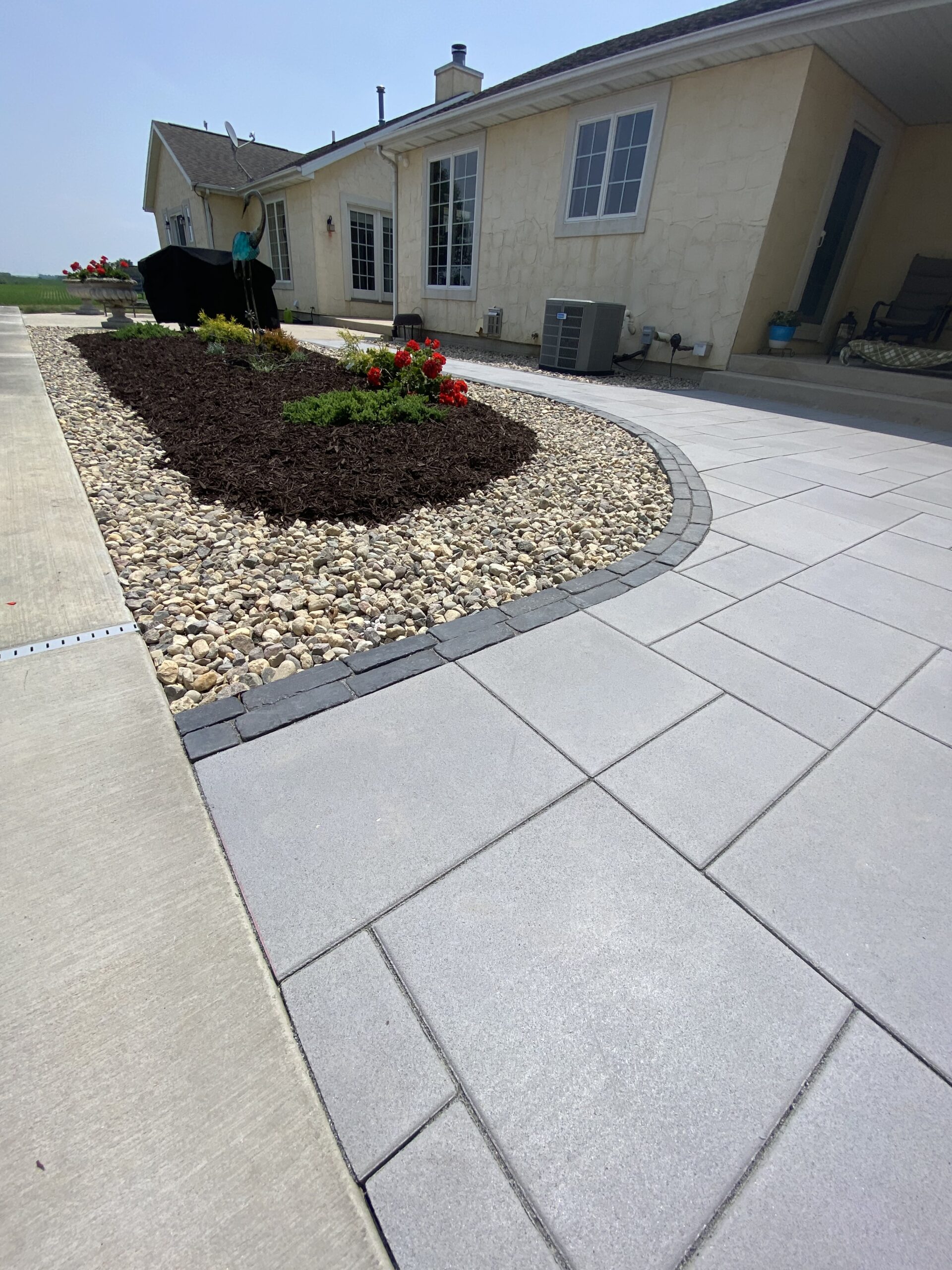 Krueger Lawn and Landscape's scenic patio area with brick and stone pavers overlooking a pool