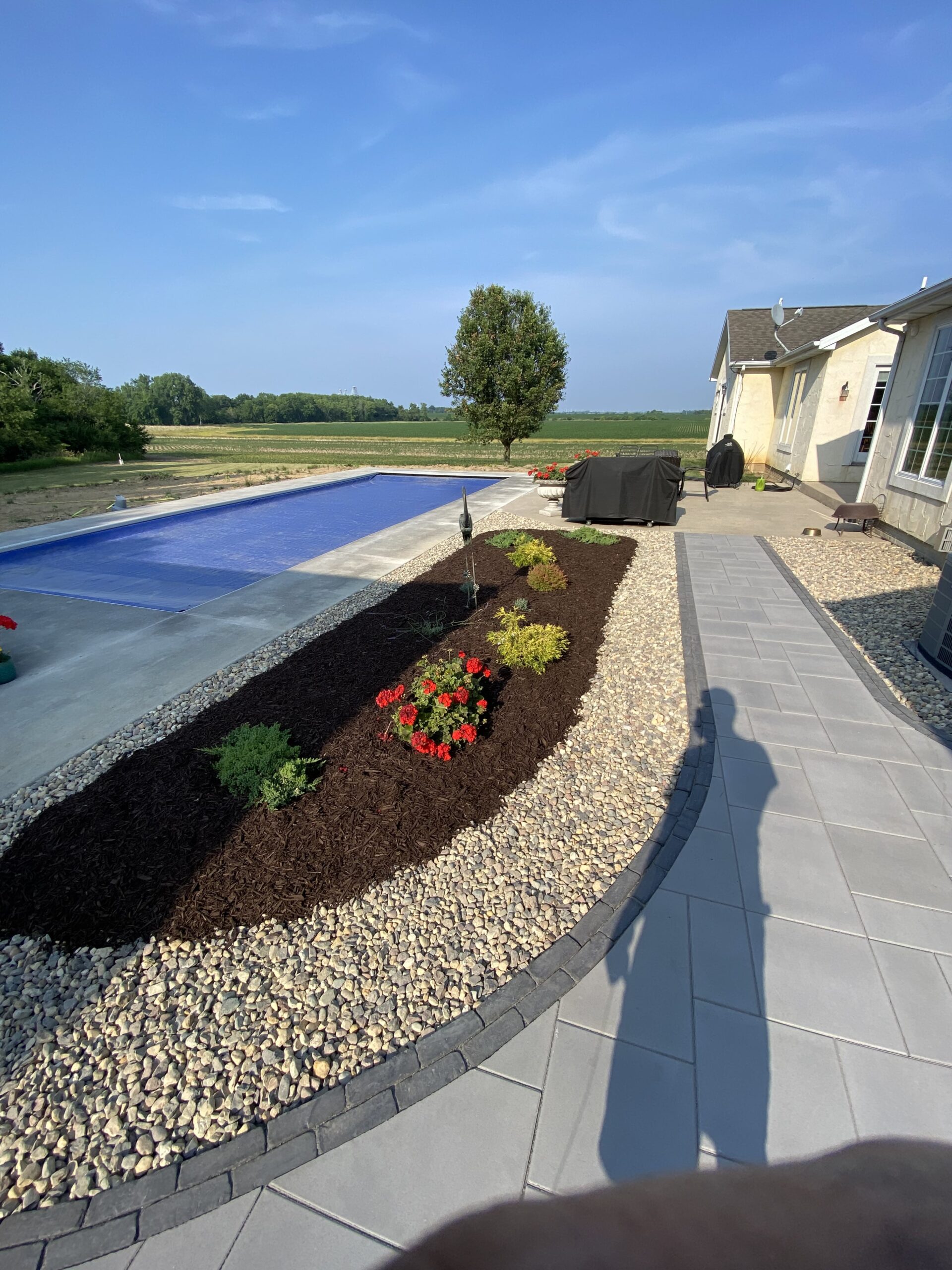 Krueger Lawn and Landscape's brick and stone paver patio beside a pool.